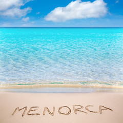 Fototapeta na wymiar Menorca word written on sand of mediterranean beach