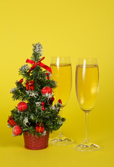 Small Christmas fir-tree in a pot, and two wine glasses