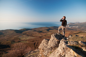Man with mobile phone on the top of world