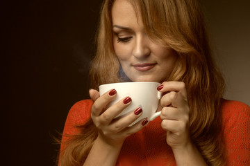 woman holding hot cup and smiles