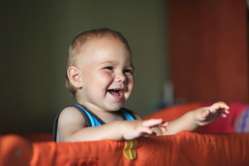a happy laughing baby standing in a cot