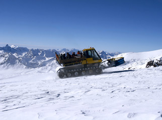 Snowcat with people going up the hill