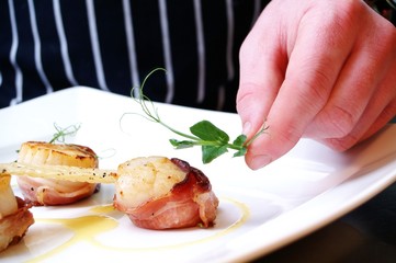chef plating cooked scallops