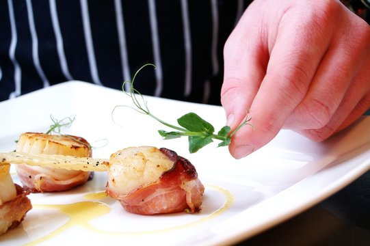 chef plating cooked scallops