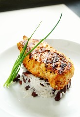 Caribbean style jerk chicken fillet with peas rice on plate