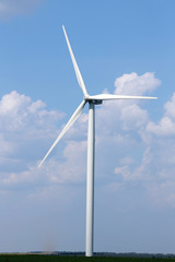 Windmill in field on blue sky background