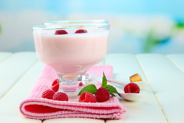 Delicious yogurt with berries on table on bright background
