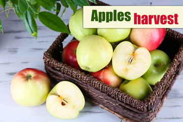 Juicy apples in basket on wooden table