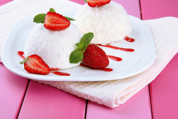 Delicious coconut cakes on plate on table close-up