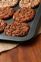 Homemade cookies on dripping pan, on wooden background