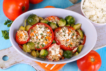 Stuffed tomatoes in bowl on wooden table close-up