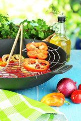 Vegetables in wok on wooden table on natural background