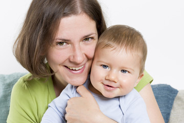 Smiling mother hugging her adorable baby boy.