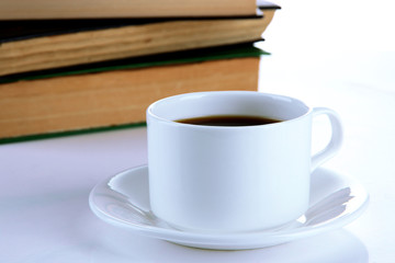Cup of coffee and books isolated on white