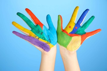 Painted hands with smile on blue background