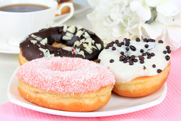 Sweet donuts with cup of tea on table close-up
