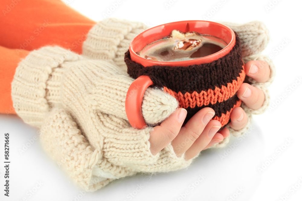 Fototapete Cup with knitted thing on it in female hands isolated on white
