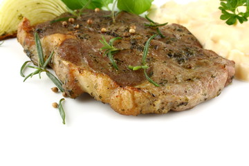 Grilled pork steak with potato salad and herbs