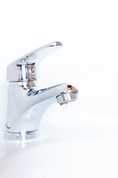 Close-up of human hands being washed under faucet in bathroom,