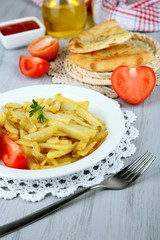 Fried potatoes on plate on wooden table close-up