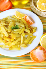 Ruddy fried potatoes on plate on tablecloth close-up