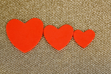 Hearts made of felt on golden background