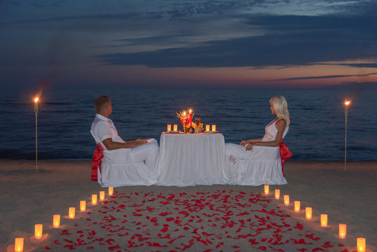 Young couple share a romantic dinner with candles and way or ros