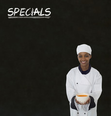 Chef with chalk specials sign on blackboard background