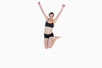 Fototapeta na wymiar Full length of a sporty young woman jumping