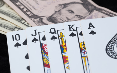 Fototapeta na wymiar Royal Flush and bank note on black background