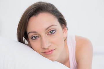 Fototapeta premium Close up portrait of a pretty woman resting in bed