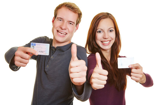 Man and woman with drivers licence holding thumbs up