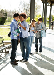 Woman Showing Mobilephone To Classmate At University Campus