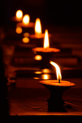 Burning candles in cley pot at Thai temple.