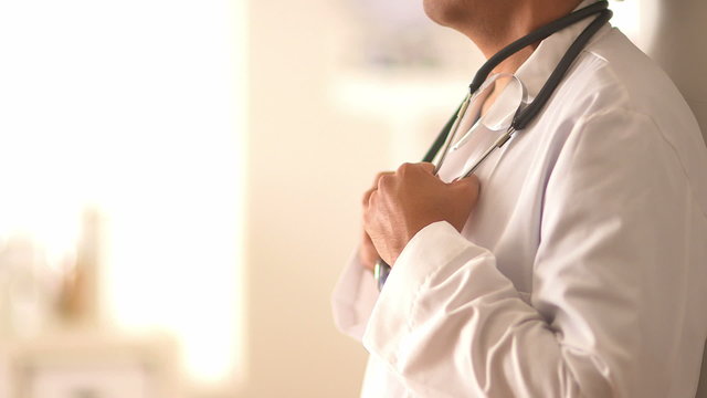 Close up of Hispanic doctor's hands holding stethoscope