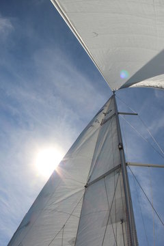 Segel und Mast einer Segelyacht bei blauem Himmel
