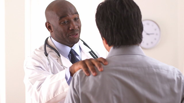 African American doctor talking to Hispanic patient