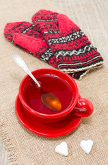 Чай в красной чашке и рукавички