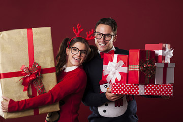 Happy nerd couple holding a lot of christmas presents
