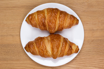 two fresh and delicious croissants on a plate