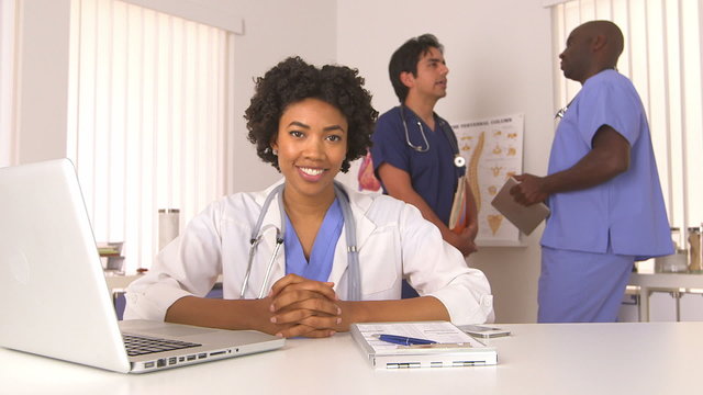 African American doctor smiling with colleagues in background