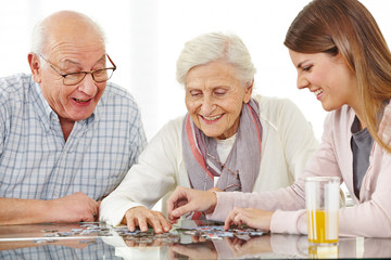 Glückliches Paar Senioren spielt Puzzle
