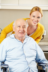 Pflegehilfe bei Senior im Rollstuhl