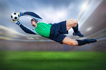 Football goalkeeper in action on field of stadium