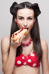 Closeup of biting off a hot dog pinup smiling model