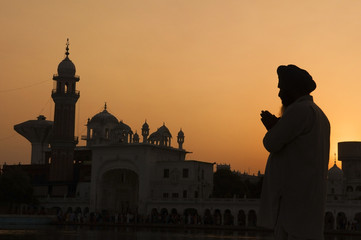 Silhouette of praying sikh man at golden temple of Amritsar, Ind