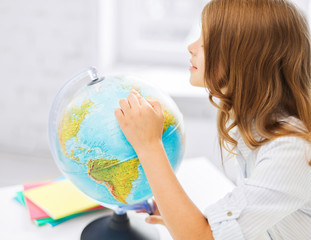 curious student girl with globe at school