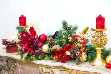 A fireplace mantle is decorated for Christmas with garland, ligh