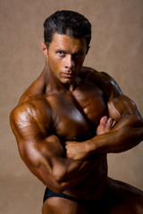 Fototapeta na wymiar Strong athletic man shows beautiful body