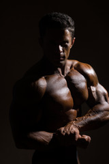 Fototapeta na wymiar Strong athletic man on dark background